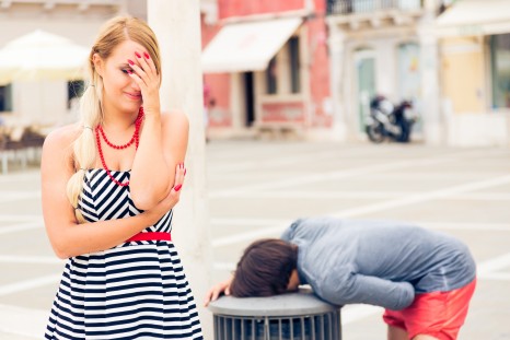 young girl feels quite embarassed when her boyfriend stops to throw up into a garbage can in town square. maybe he drank too much or maybe those clams he had were not all that fresh.
