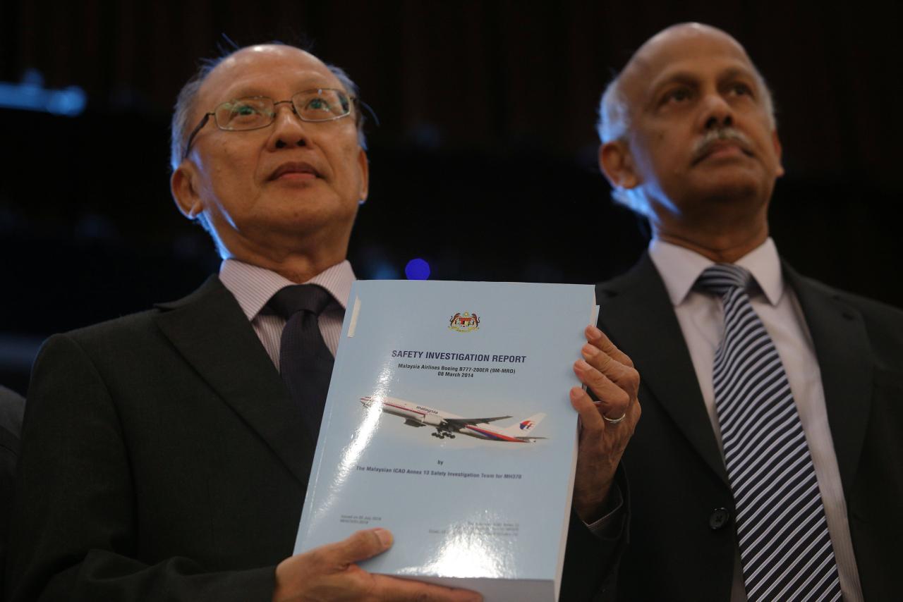 MH370 safety investigator-in-charge Kok Soo Chon shows the MH370 safety investigation report booklet to the media after a news conference in Putrajaya, Malaysia July 30, 2018. REUTERS/Sadiq Asyraf