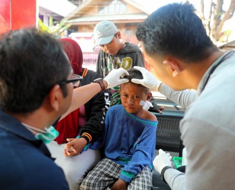 PALU, INDONESIA - OCTOBER 01: (CHINA OUT, SOUTH KOREA OUT) A 7-year-old injured boy, whose mother and young sister remain missing, receives treatment after strong earthquake on October 1, 2018 in Palu, Indonesia. Over 844 people have been confirmed dead after a tsunami triggered by a magnitude 7.5 earthquake slammed into Indonesia's coastline on the island of Sulawesi, causing thousands of homes to collapse, along with hospitals, hotels and shopping centers. Emergency services fear that the death toll could rise into the thousands as rescue teams made contact with the nearby cities of Donggala and Mamuju and strong aftershocks continue to rock the city. (Photo by The Asahi Shimbun/The Asahi Shimbun via Getty Images)